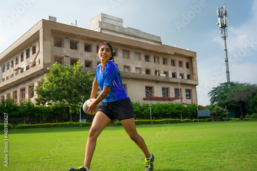 Young Indian girl practicing rugby on the grassy field photo