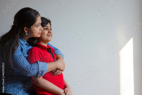 Indian woman hugging her son from backside