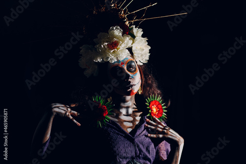 Woman with mexican skull halloween makeup on face. Day of the dead aka Dia de los Muertos and halloween concept.