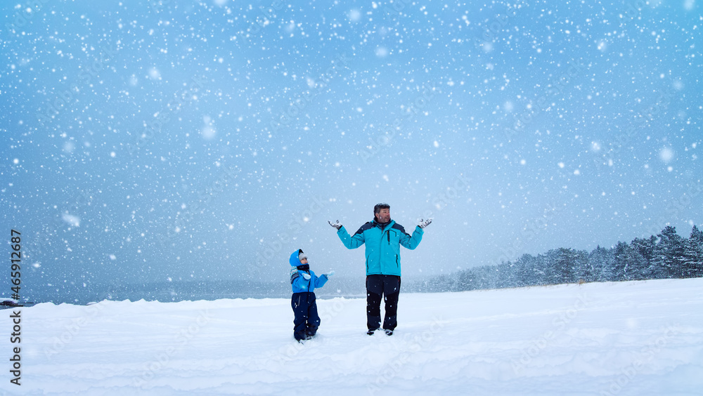 Father and his son standing on the snowfall in the snowy winter forest Father and his son standing on the snowfall in the snowy winter forest
