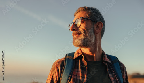 Canvas Print Carefree backpacker looking away while standing outdoors