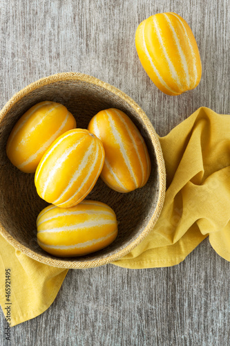 Korean melons in a basket with yellow kitchen cloth
