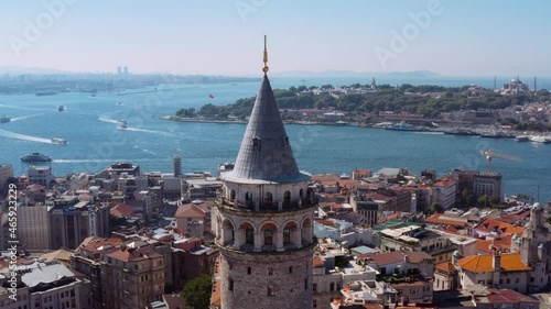 Galata Tower of Istanbul with majestic cityscape view and boats in water, aerial orbit view photo