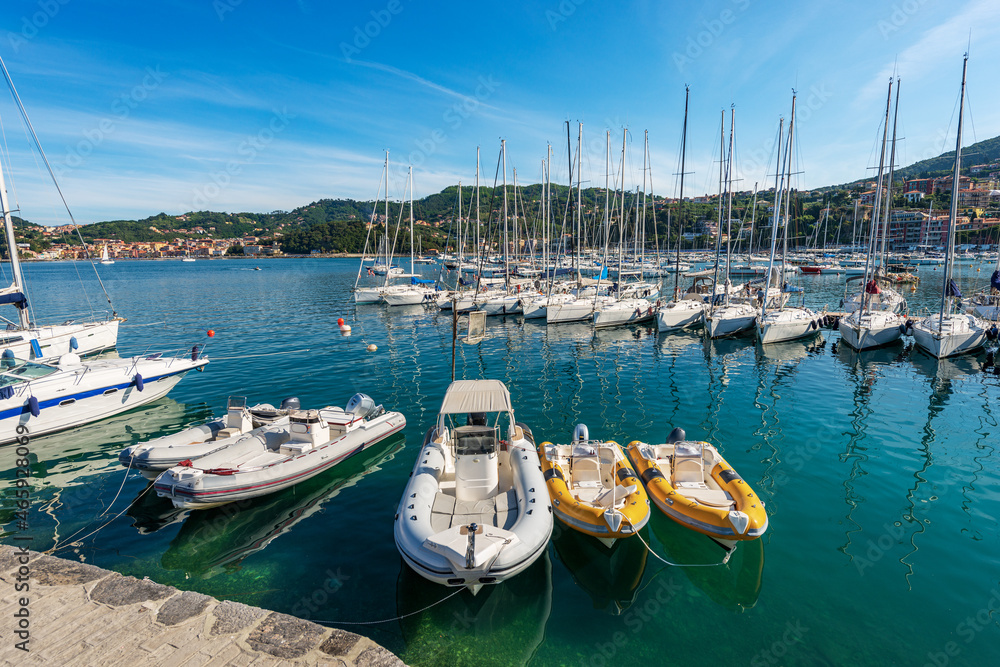 Port of the small Lerici town with many boats moored. Tourist resort on the coast of Gulf of La Spezia, Mediterranean sea, Liguria, Italy, Southern Europe. On the left the small village of San Terenzo