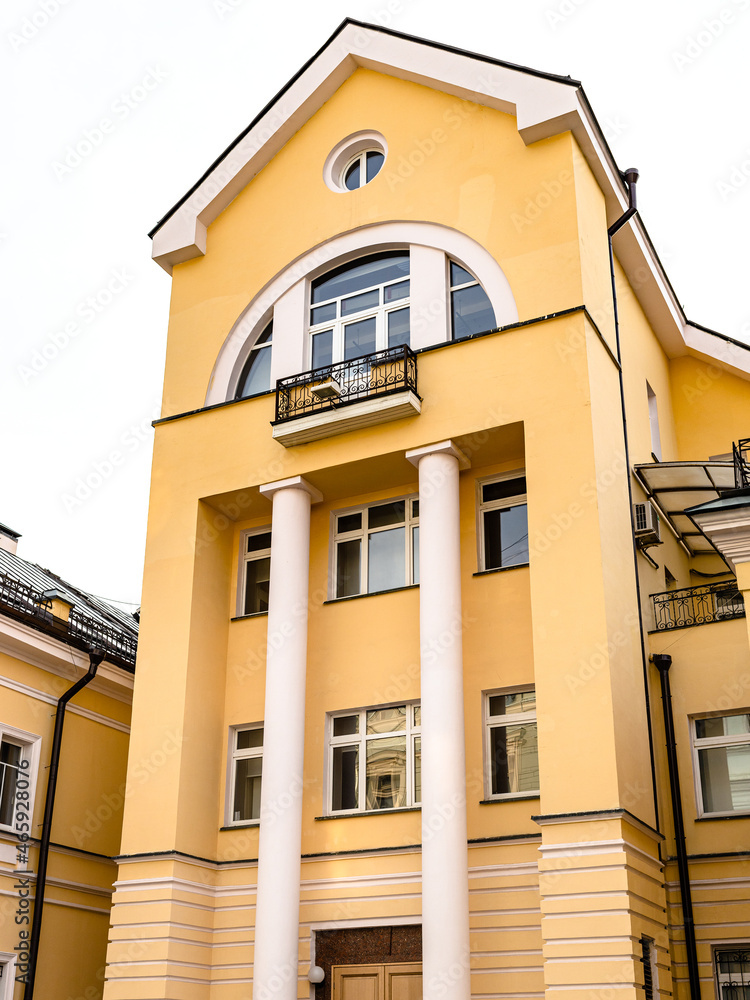 Fototapeta premium yellow facade with columns of building on Rozhdestvenka street in Moscow city in evening
