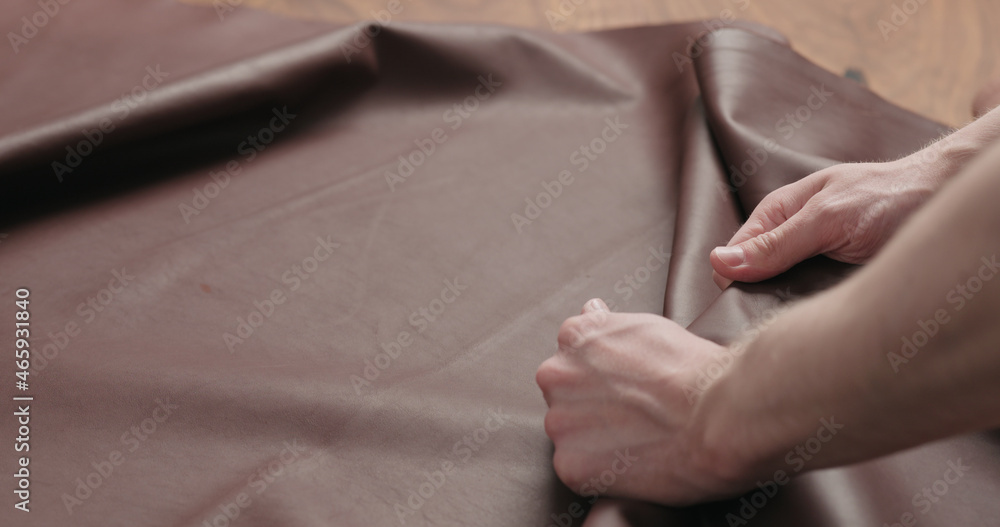 man hand checking brown leather piece closeup man hand checking brown leather piece closeup