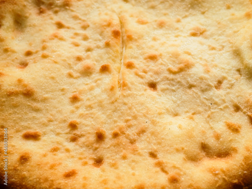 flat closed Ossetian pie stuffed with cheese and potatoes closeup