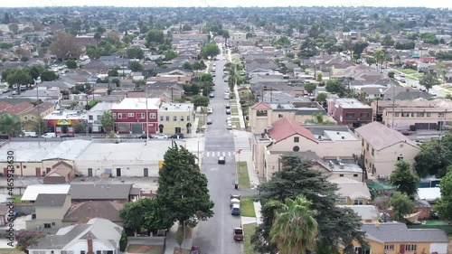 Crenshaw neighborhood of houses, following car on urban street, aerial follow photo