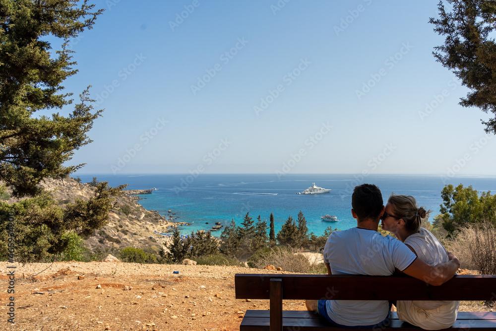 Back view of lovely couple relax on bench sitting near the sea. Wanderlust Back view of lovely couple relax on bench sitting near the sea. Wanderlust