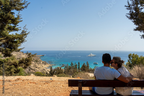 Back view of lovely couple relax on bench sitting near the sea. Wanderlust © Anton Tolmachov