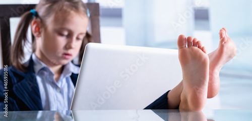 Canvas Print Humorous photo of happy child business girl is resting and working at the same time