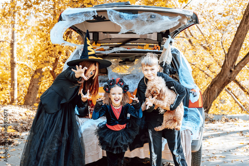 Canvas Print siblings boy in skeleton costume, teenage girl in witch costume and hat and cute