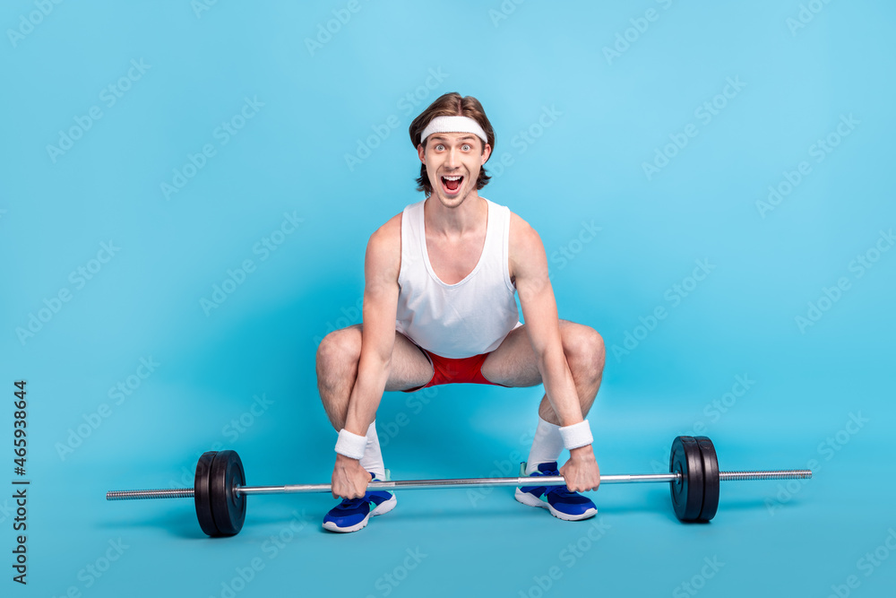 Full length body size photo male athlete keeping barbell wearing sportswear isolated pastel blue color background Full length body size photo male athlete keeping barbell wearing sportswear isolated pastel blue color background