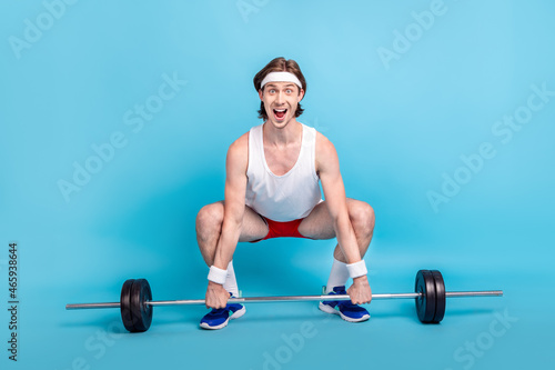 Full length body size photo male athlete keeping barbell wearing sportswear isolated pastel blue color background