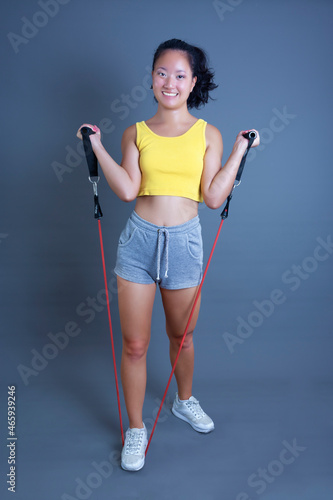 smiling chinese young woman with rubber resistance bands