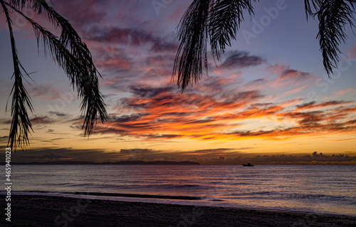 Precioso e impactante amanecer. Salida del sol y cielos impresionantes en la playa. Cielo rojo y dorado al amanecer en la costa.