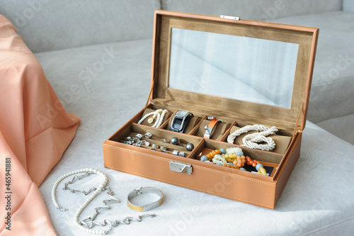 фотографія Leather jewelry box with jewelry and accessories laid on a couch