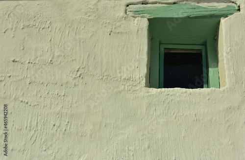 A small old-fashioned window with green wooden frame in a whitewashed wall © Gerrit Rautenbach