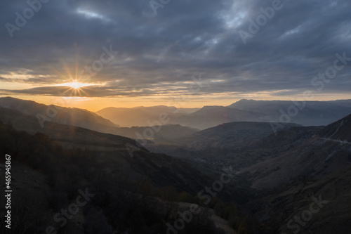 Last rays of the setting sun over a mountainous plateau. Golden sunset in mountain landscape. Silhouette of the evening mountains at sunset. Matlas Valley at sunset in Dagestan.