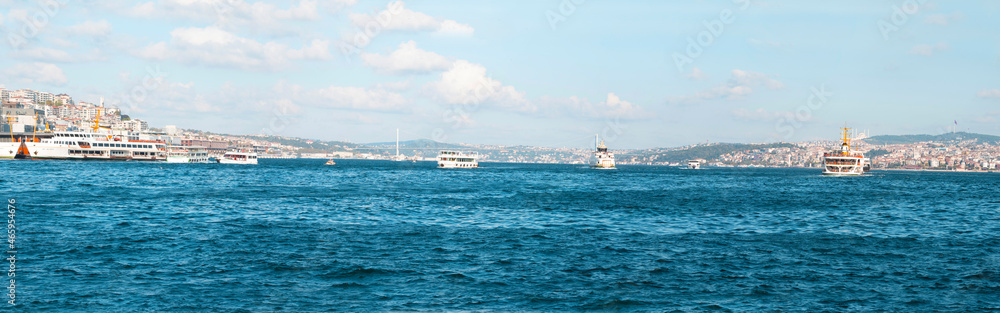 Large panoramic view of the Bosphorus strait with bridge, ships and architecture during sunny summer day in Istanbul, Turkey.