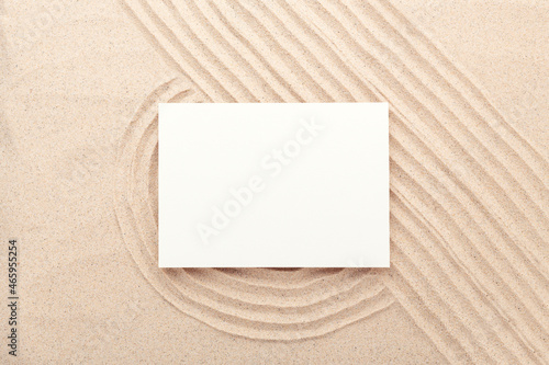 Blank card mockup on sand background. Lines drawn on the sand. Top view. Minimal design