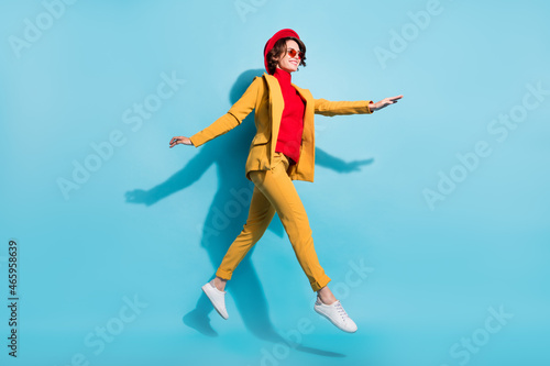 Full length body size view of attractive cheerful carefree girl jumping going isolated over bright blue color background