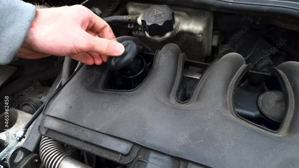 Engineer checks the engine oil for service and repair in a car service Engineer checks the engine oil for service and repair in a car service