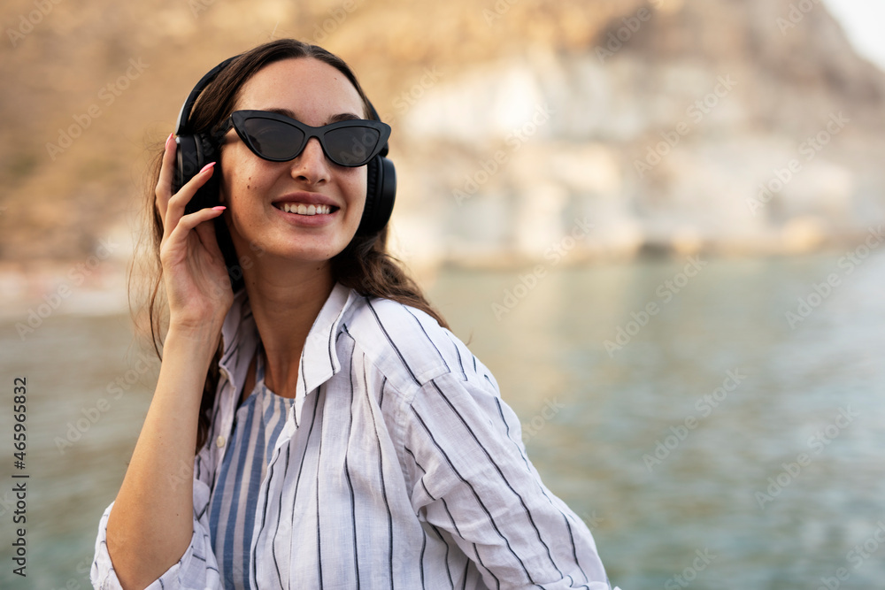 Hot woman relaxing on the sandy beach. Beautiful woman with headphones listening the music.. Hot woman relaxing on the sandy beach. Beautiful woman with headphones listening the music..