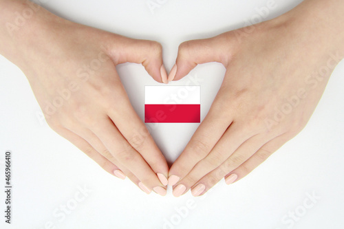 Women's hands create a heart inside the flag of Poland on a white background.Background for postcards and banners for the Independence Day of Poland, Flag Day, Constitution Day, travel, patriotism