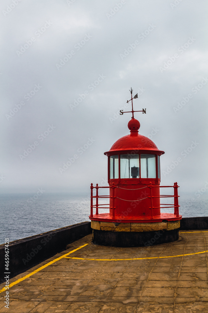 Red lighthouse with the ocean in the background