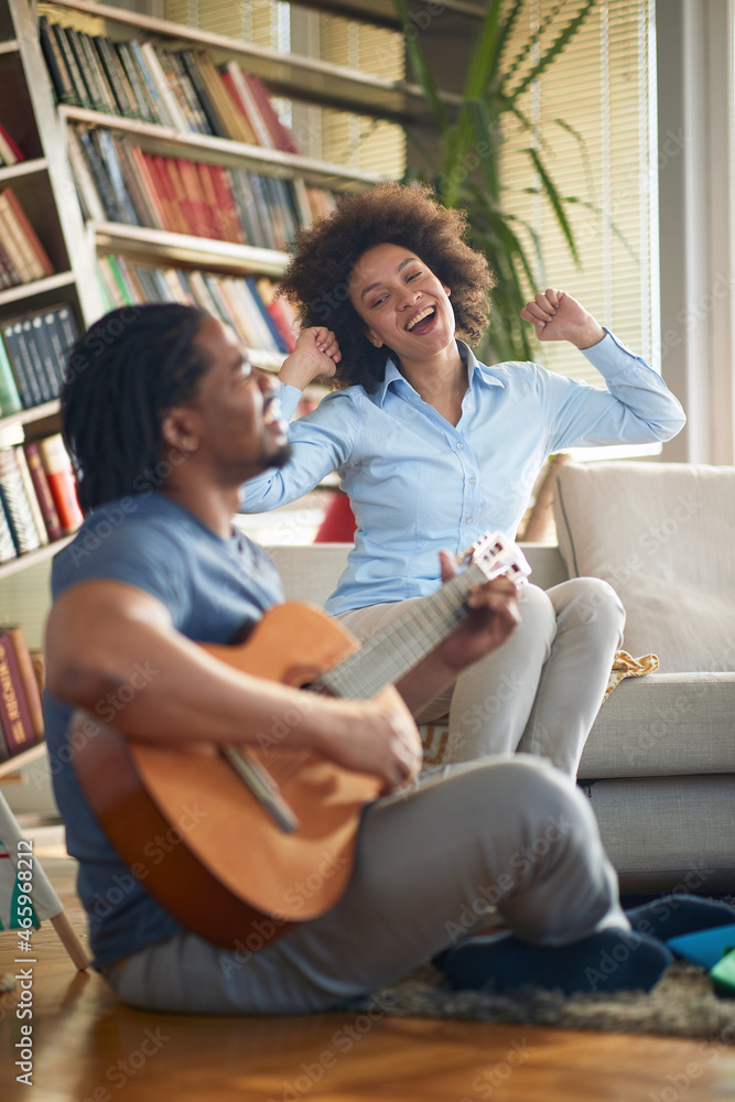 Young spouses singing and playing the guitar at home together. Family, together, love, music Young spouses singing and playing the guitar at home together. Family, together, love, music