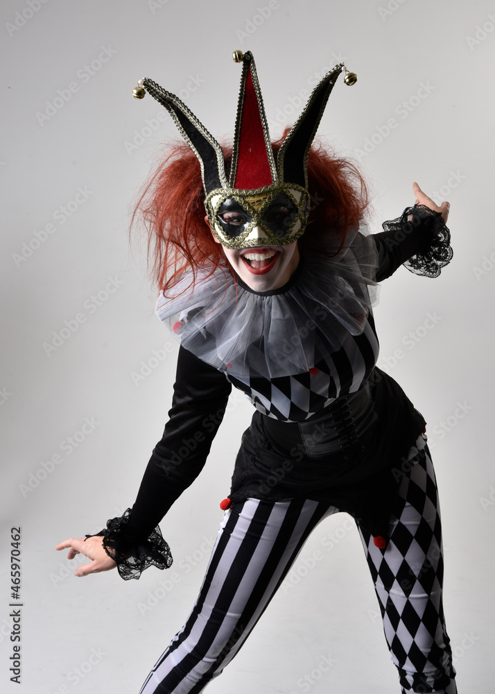 Φωτογραφία close up portrait of red haired  girl wearing a black and white clown jester costume, theatrical circus character
