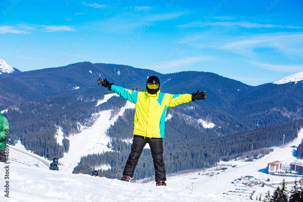 man on the top of the hill with snowboard in sunny day
