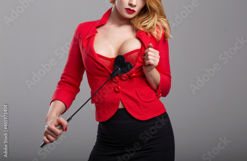 Sexy dominant blonde woman in red with whip photo