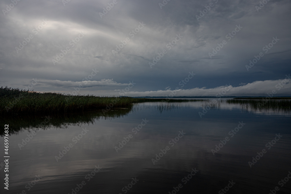Blue sky and lake. Blue sky and clouds over lake horizon background with smooth water. Dark  gloomy beautiful landscape