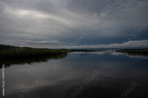 Blue sky and lake. Blue sky and clouds over lake horizon background with smooth water. Dark  gloomy beautiful landscape