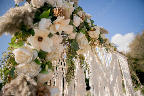 arch design with flowers and macrame for a photo shoot of a wedding ceremony at sunset on the seashore