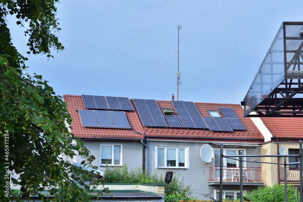 Solar panels on the roof of a small family house, trees and sky. Summer. Solar panels on the roof of a small family house, trees and sky. Summer.