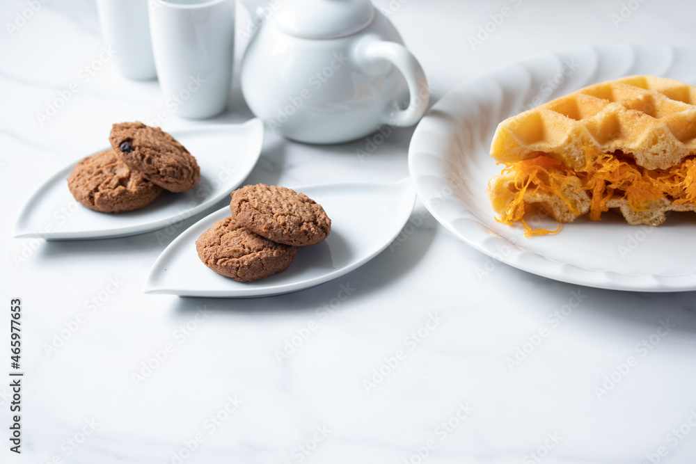 Cookies in a white plate, teapot, afternoon snack. Cookies in a white plate, teapot, afternoon snack.