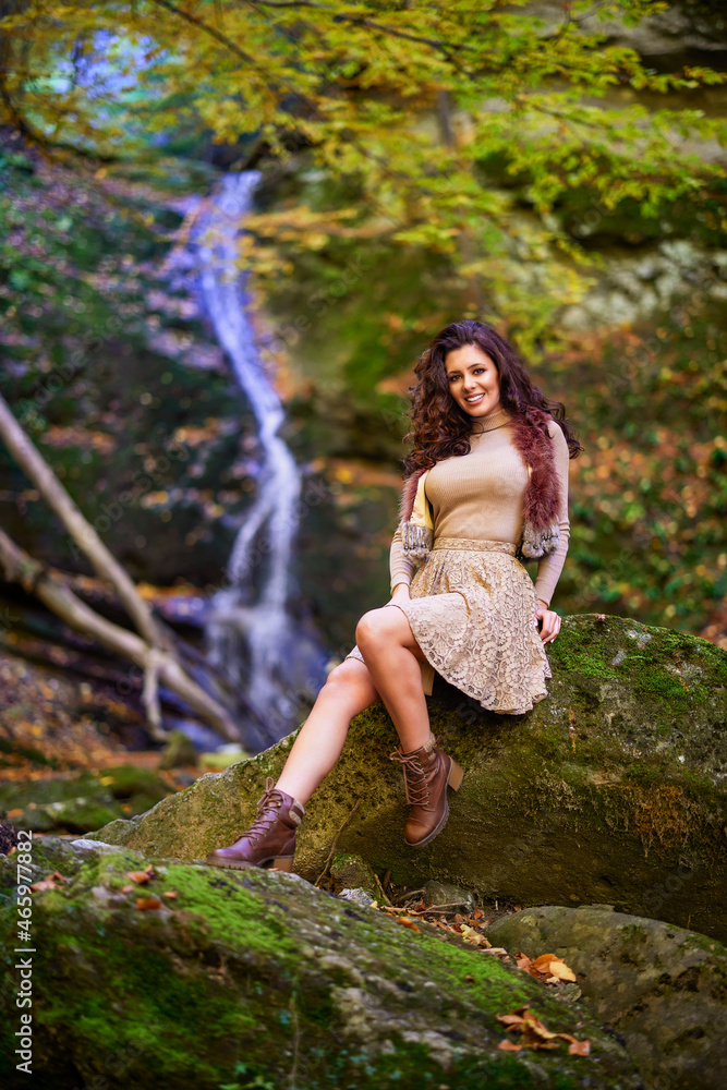 a beautiful woman sitting by a waterfall in different positions. a beautiful woman sitting by a waterfall in different positions.