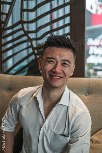 Portrait of asian young handsome man in black shirt sitting in coffee shop and smiling. Lovely smile, Happy person, millennials life, lifestyle