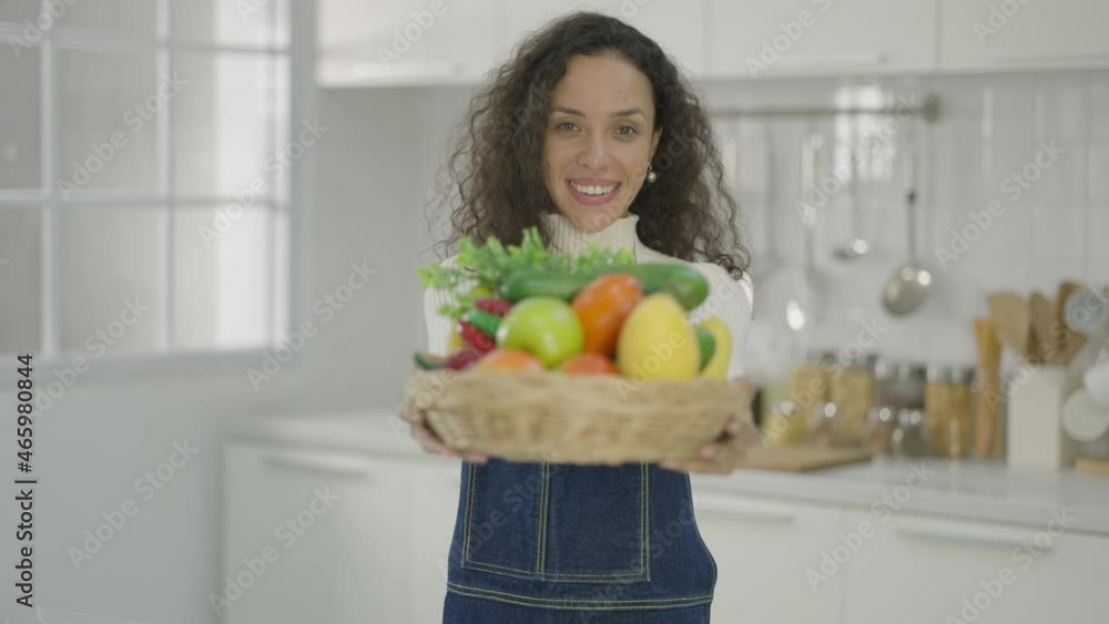A beautiful woman or housewife is carrying a basket of fresh vegetables prepared for cooking healthy food for the family. Stay at home. receive food orders for delivery. A beautiful woman or housewife is carrying a basket of fresh vegetables prepared for cooking healthy food for the family. Stay at home. receive food orders for delivery.