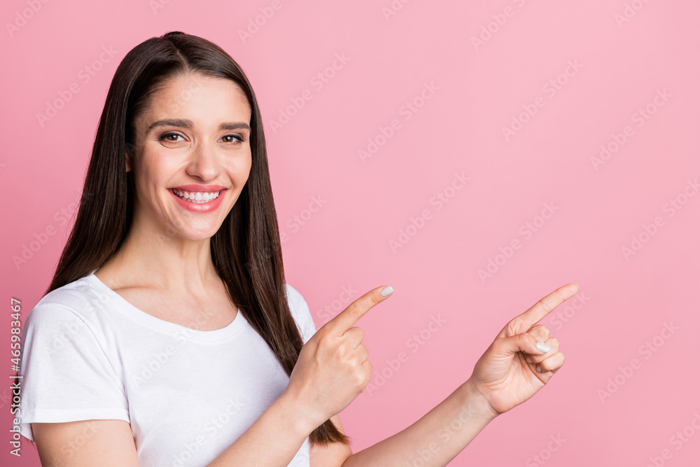 Photo portrait young woman smiling in casual clothes pointing copyspace isolated pastel pink color background Photo portrait young woman smiling in casual clothes pointing copyspace isolated pastel pink color background