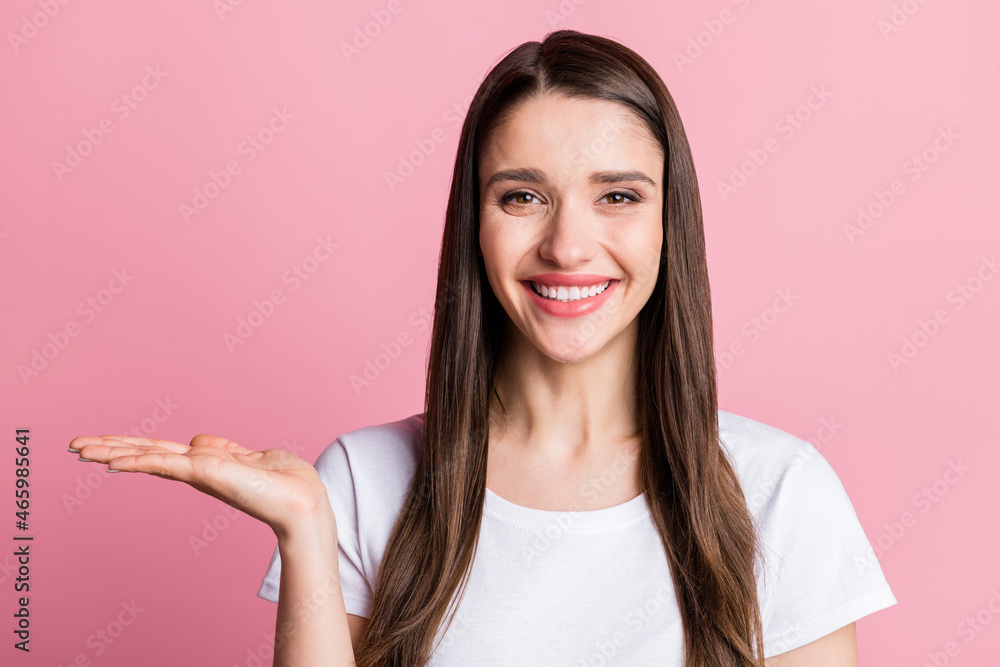 Portrait of attractive cheerful girl holding on palm copy empty space ad new novelty isolated over pink pastel color background Portrait of attractive cheerful girl holding on palm copy empty space ad new novelty isolated over pink pastel color background