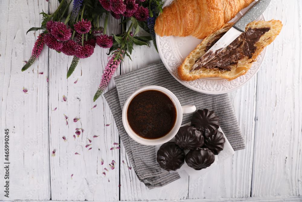 Marshmallow in chocolate, croissant and black coffee with cinnamon on a white wooden background