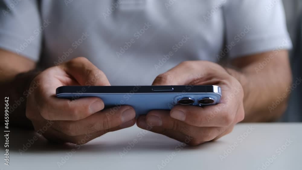 Playing mobile game on Apple Iphone 13 Pro smartphone. Man plays games on new trendy mobile phone with three cameras Playing mobile game on Apple Iphone 13 Pro smartphone. Man plays games on new trendy mobile phone with three cameras