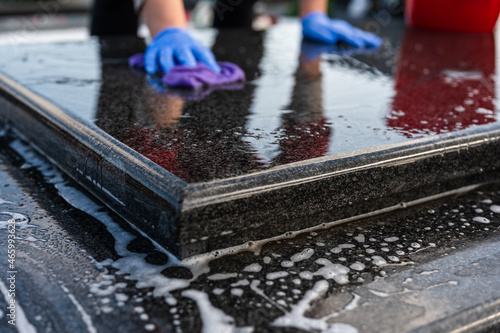 Foto Unrecognizable woman washing the tombstone with a brush