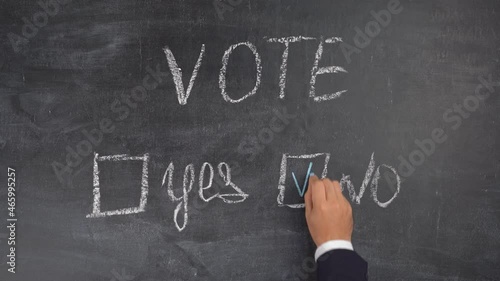 The concept of elections, voting against. A woman's hand puts a tick next to the word NO.