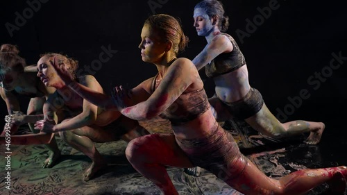 a group of women covered with multicolored paint performs an art performance dance photo