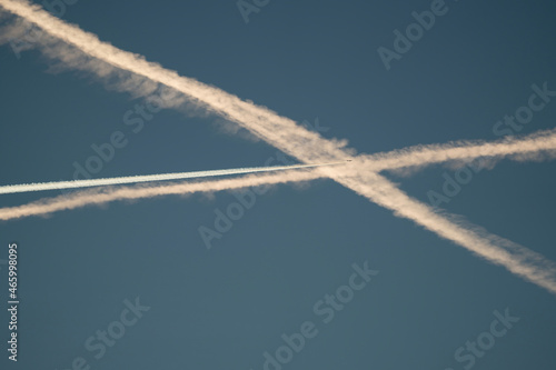 crossed vapor trails on the blue sky at the morning © Chamois huntress